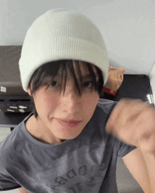a person wearing a white beanie and a t-shirt that says aoo on it
