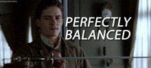 a man is holding a sword and the words perfectly balanced are behind him