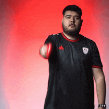a man with a beard wearing a black adidas shirt