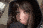 a close up of a woman wearing a hooded jacket covering her face .