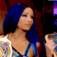 a woman with blue hair is holding a wrestling championship
