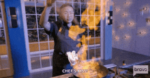 a woman is cooking in a kitchen with flames coming out of a pan and says chef 's kiss