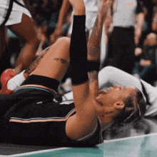 a basketball player laying on the floor with her arms outstretched