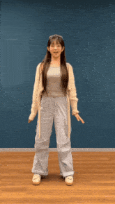 a girl with long hair is standing in front of a blue background