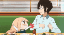 a man and a girl are sitting at a table with a bottle of ketchup on the table .