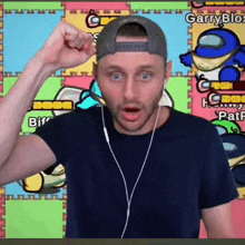 a man wearing headphones and a hat is standing in front of a colorful background with among us characters .