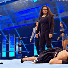 a woman standing in a wrestling ring with a w logo on it