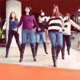 a group of women are dancing together in a room .