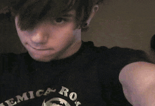 a young man wearing a black shirt that says ' erica rock ' on it