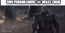 a man in armor is standing in front of a crowd of people and a sign that says `` this person above react them '' .