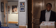 a man in a suit is holding a box of pizza in front of a door that has the number 35 on it