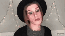 a woman is wearing a hat and making a funny face .