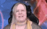 a woman wearing headphones and a scarf is smiling