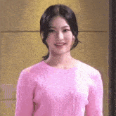 a close up of a woman wearing a pink sweater and smiling .