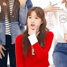 a girl in a red sweater is making a funny face .