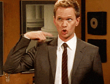 a man in a suit and tie is pointing his finger