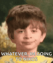 a young boy is smiling with the words whatever im going to nikos below him