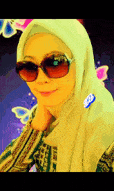 a woman wearing a hijab and sunglasses stands in front of butterflies