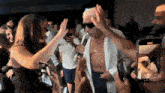 a man without a shirt is singing into a microphone in front of a crowd of people