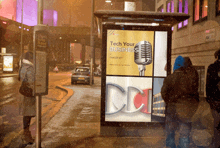 a bus stop with a sign that says tech your business on it