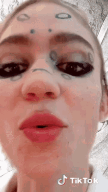 a close up of a woman 's face with tiktok written on the bottom right corner .
