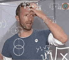 a man scratches his head while looking at a chalkboard with math equations on it