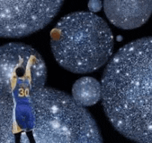 a basketball player is standing in front of a bunch of blue balls and throwing a ball .