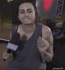 a woman wearing a tank top with a microphone that says ' nsj ' on it