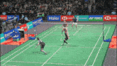 a badminton game is being played on a court sponsored by haier