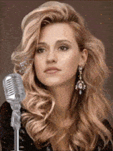a woman stands in front of a silver microphone with a music note in her hair
