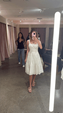 a woman is taking a picture of herself in a dressing room