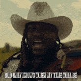 a man in a cowboy hat is holding a violin with the words god only knows when my time will be above him