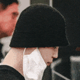 a person wearing a black hat and a white mask