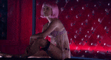 a woman with purple hair is laying on a bed