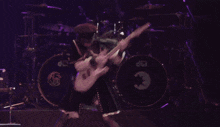 a woman playing a guitar in front of a drum set that says dw on it