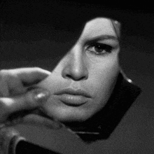 a woman is looking at her reflection in a mirror .