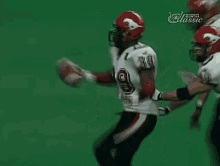 a group of football players are running on a field .