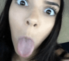 a close up of a woman making a funny face with her tongue hanging out .