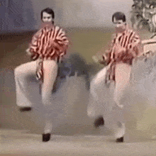 a couple of men are dancing on a stage .
