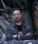 a man with a beard wearing a watch and a gray jacket