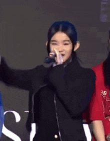a girl wearing a black sweater and a red shirt that says 29 on it