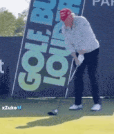 a man in a red hat is swinging a golf club on a golf course .