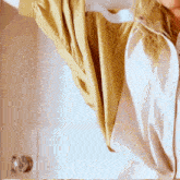 a woman is standing in front of a door with her arms outstretched and wearing a yellow shirt .