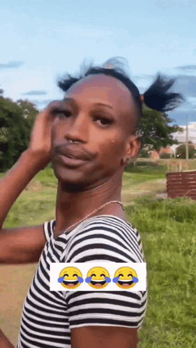 a man wearing a striped shirt is making a funny face with three smiley faces .