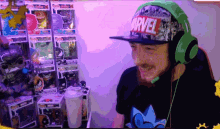 a man wearing headphones and a marvel hat