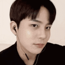 a close up of a young man wearing earphones .