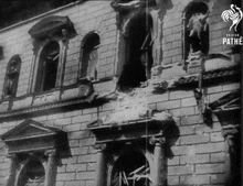a black and white photo of a destroyed building with pathe written on the bottom right