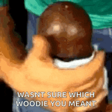 a person is holding a chocolate egg in their hands and the words `` wasnt sure which woodie you meant '' are visible .
