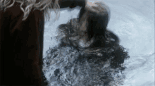 a woman is standing next to a woman in a pool of water .