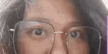 a close up of a woman wearing glasses and making a funny face .